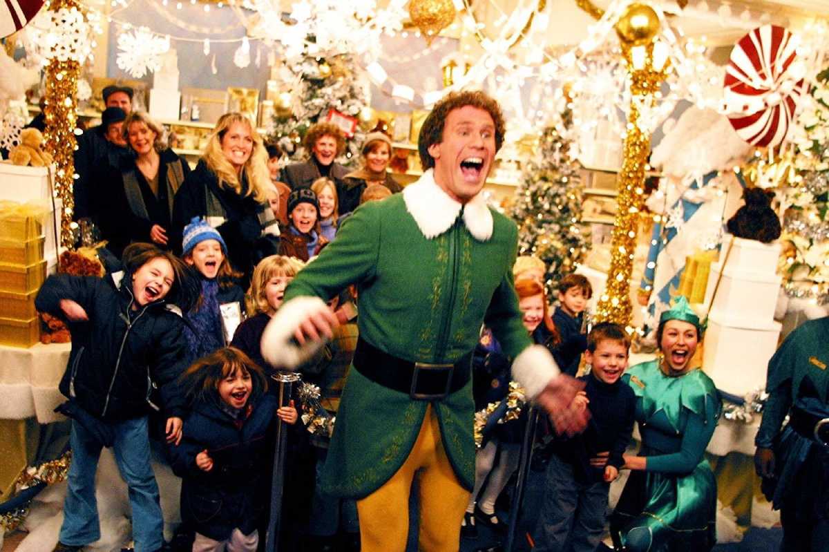 Buddy The Elf with some kids and adults laughing together in one scene of the movie