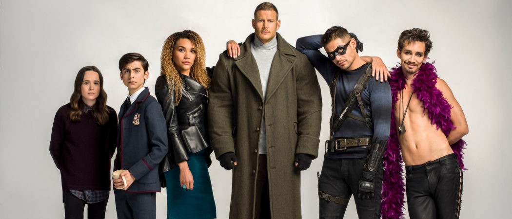 Two ladies and 4 men in a group photo for the umbrella academy shoot