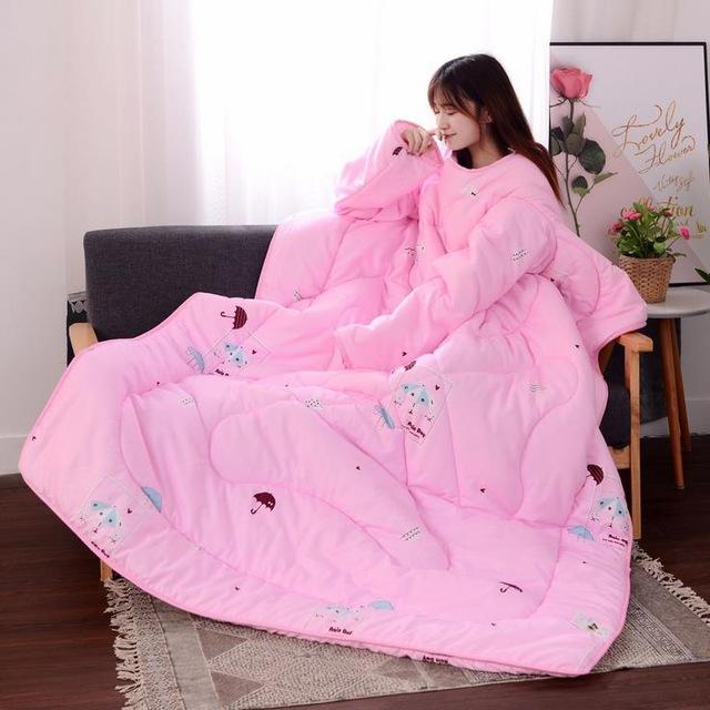 A girl a pink sleeved blanket sitting on a sofa 