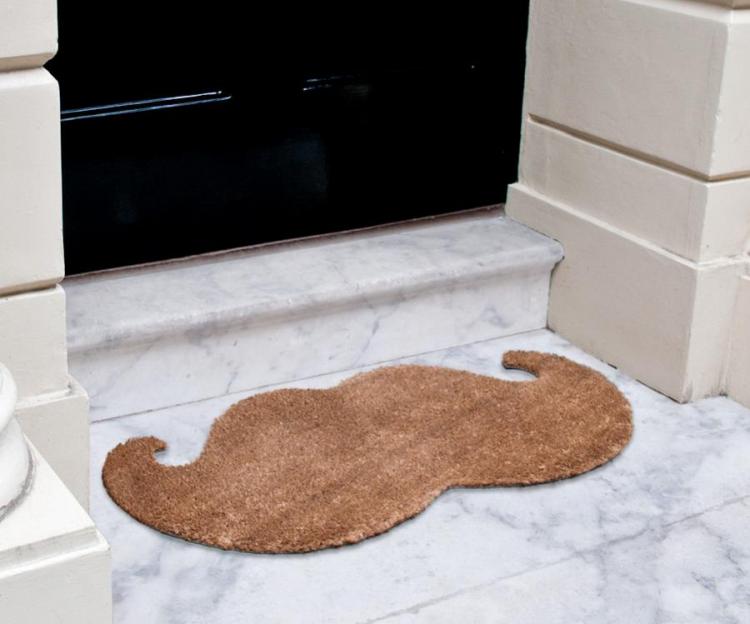 A brown moustache shaped rug doormat on a white and grey marble floor