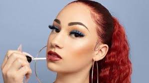 Cash me outside girl applying red lipstick on her lips;her red-colored hair tied in a high ponytail