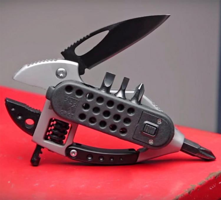 Grey and black colored multi-purpose tool placed on a red surface