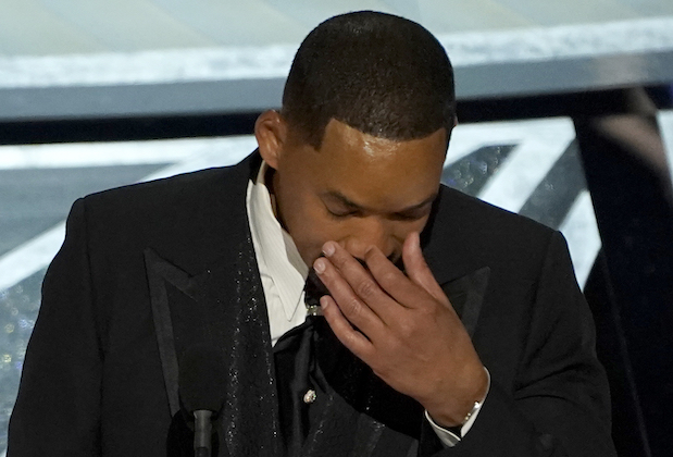 At the OSCAR's stage, Smith wearing black coat while he wipes his tears