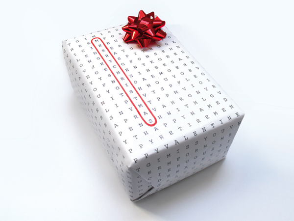 White word scribble paper wrapped on a box with red ribbon