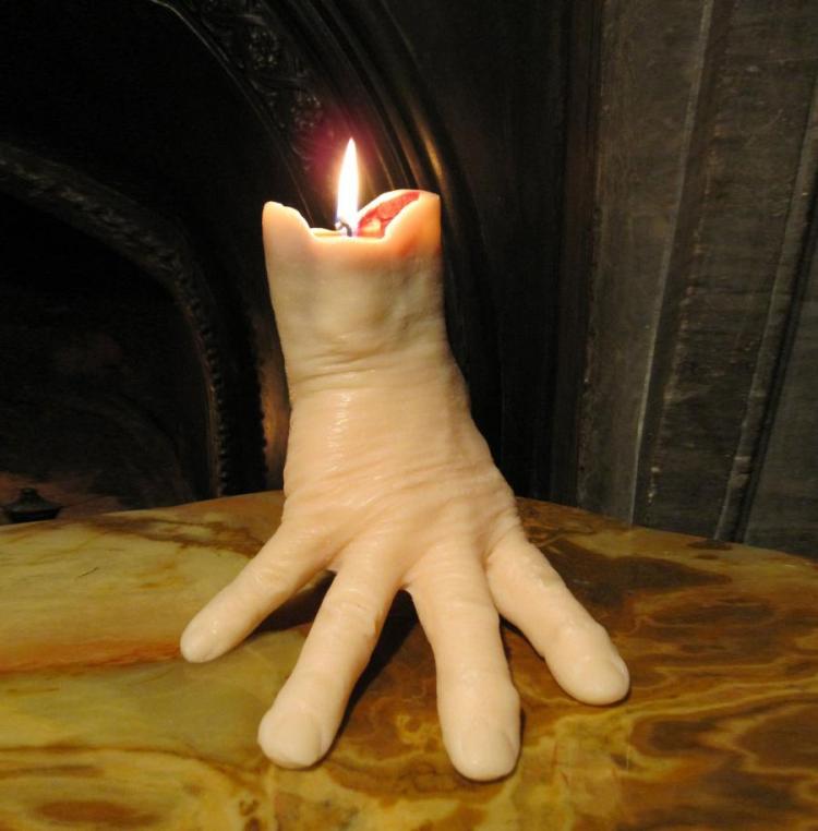 A realistic hand candle on a brown-yellow marble tabletop