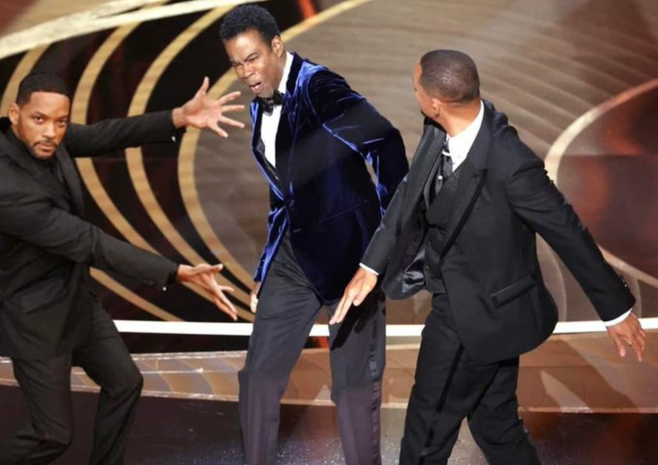 Will smith arms spread open to show off another him slapping chris rock