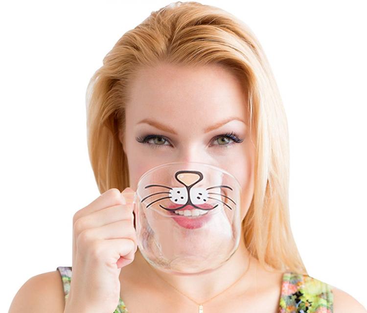 A girl drinking in a cat beard glass coffee mug 