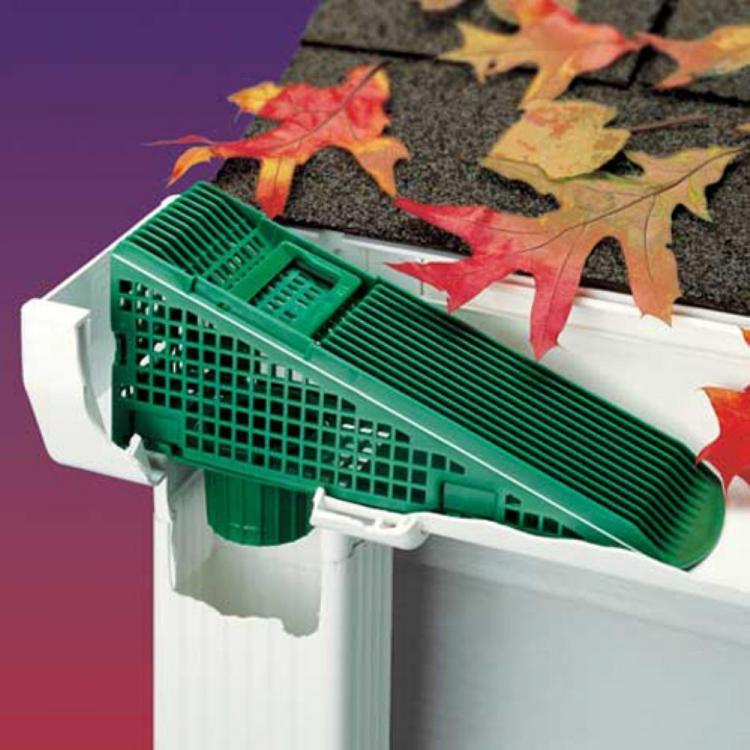 A green-colored gutter leaf filter filtering the leaves in a white pipe