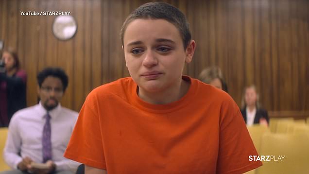 A bald girl wearing an orange jail dress in the courtroom
