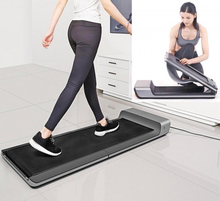 A woman wearing a white shirt and black bottom running on a black mini foldable treadmill