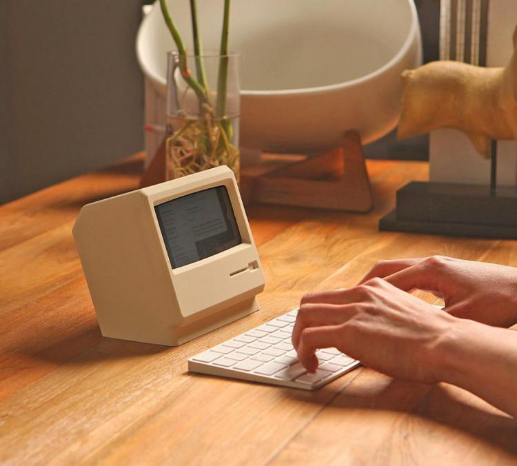 Mini white old pc with a white keyboard on a wooden table