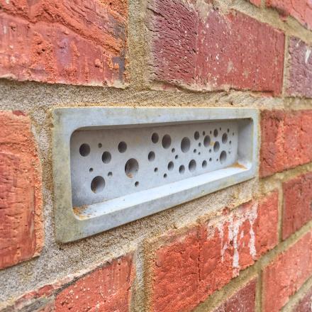 White concrete bee brick installed in a wall
