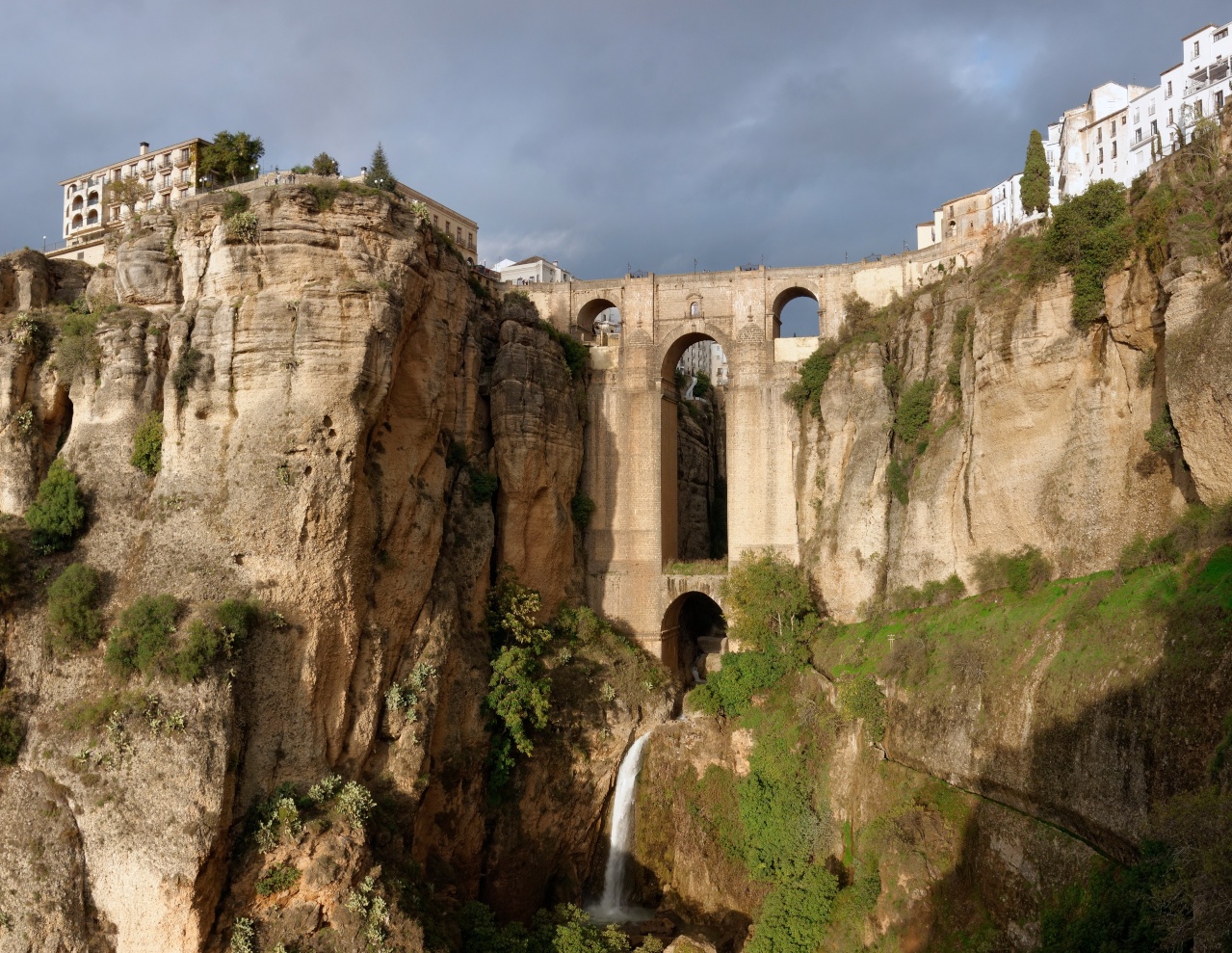 Waterfall beneath bridges on the mountains of Ronda town in Spain