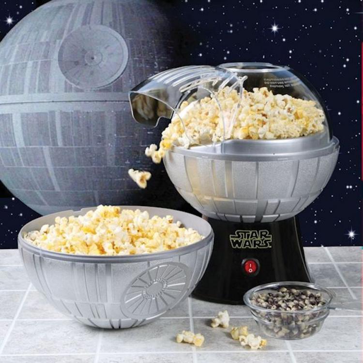 Gray colored star wars death star themed popcorn machine filled with popcorns against a death star themed background