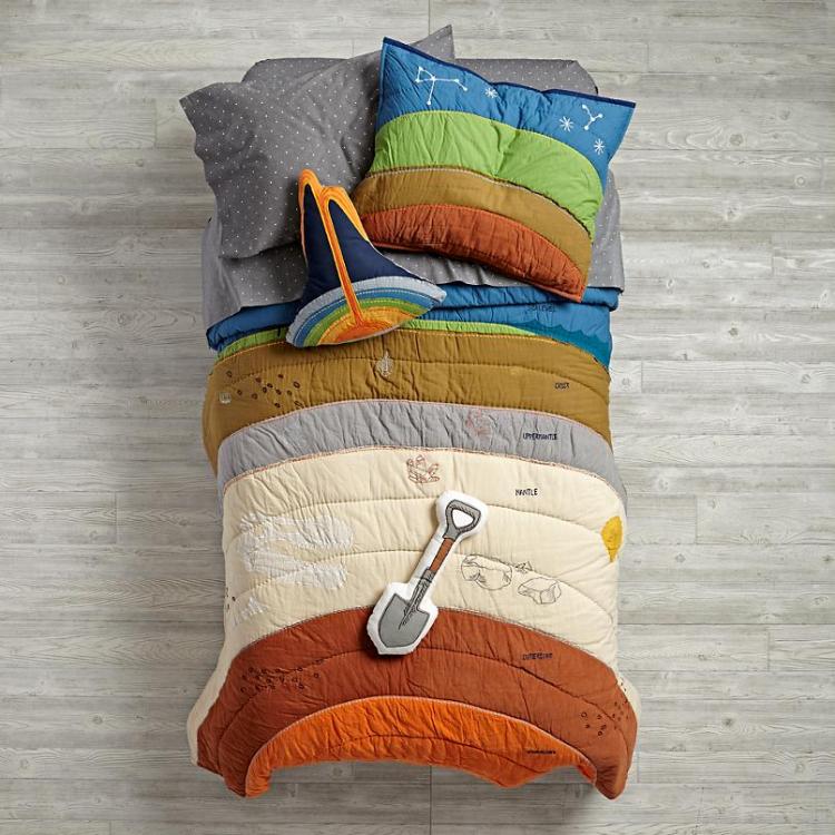 Multi-colored geographical earth layers themed comforter, bedsheet, shovel pillow on a grey wooden floor