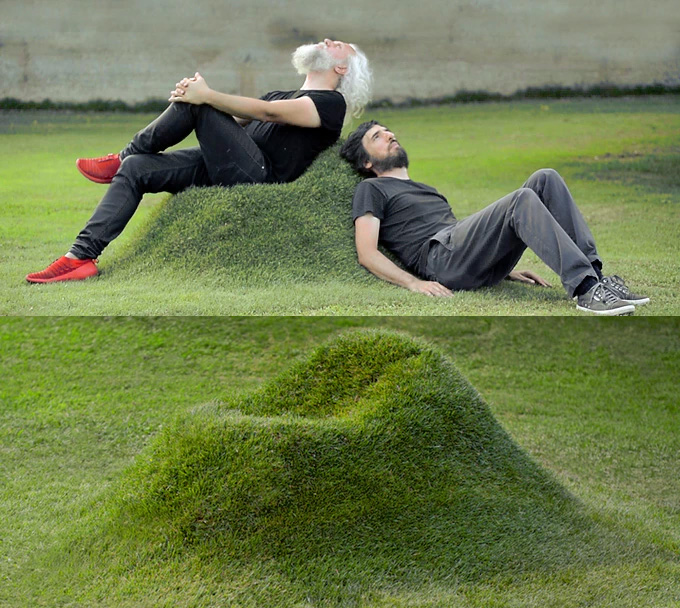 Two black shirts wearing men relaxing on a cardboard grass chair in the garden
