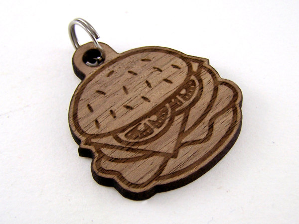 A wooden carved cheeseburger dog tag