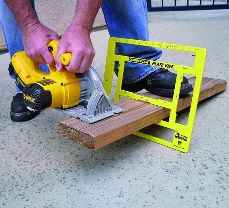 Yellow colored tool cutting a piece of wood on the marble floor
