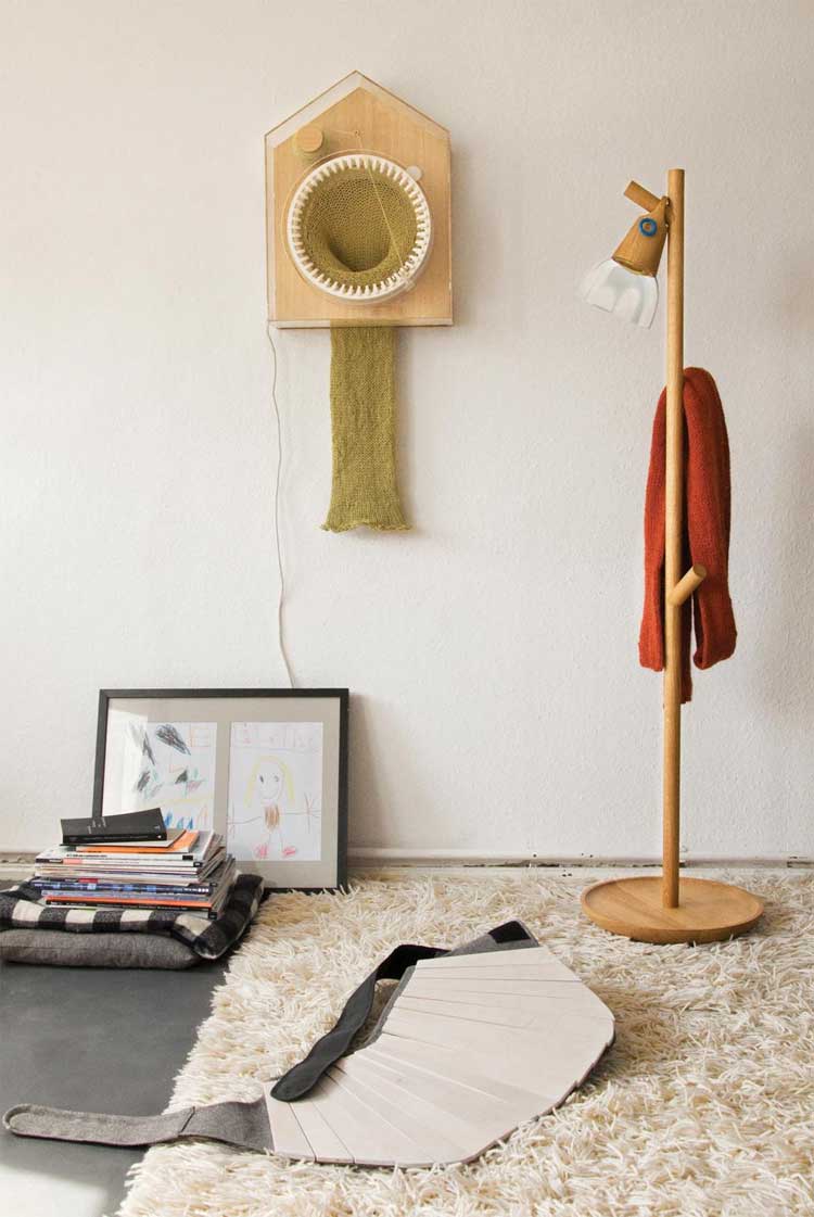 White Scarf Knitting Clock with green thread and scarf in it on a white b in a room