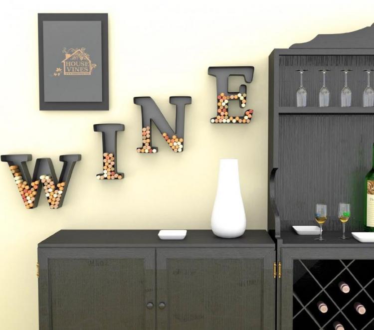Black colored 'WINE' alphabets filled with corks on a skin-white wall near complete black furniture