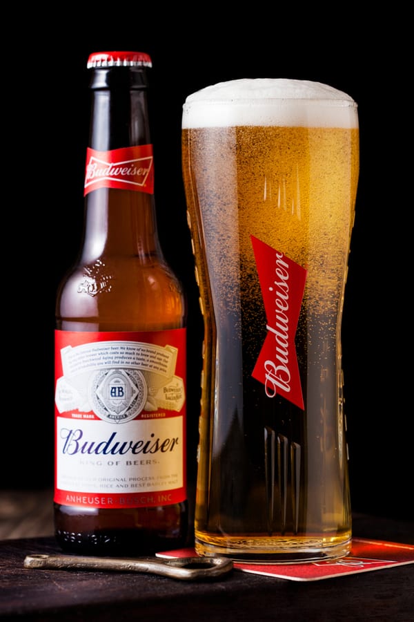 Budweiser actual ventured bottle and a pint glass filled with Budweiser beer