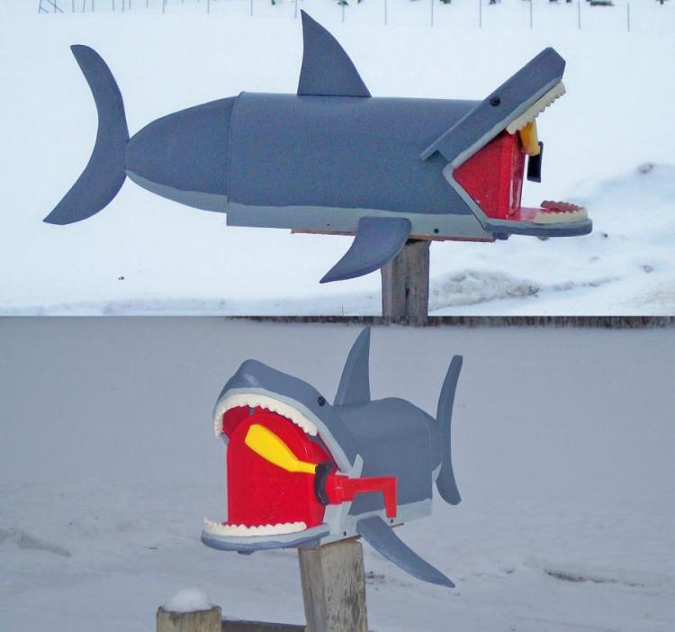 Grey and read-colored shark mailbox in a snow