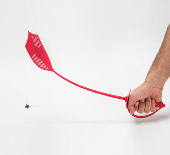 A hand is holding a red-colored sword fly swatter trying to kill the bug