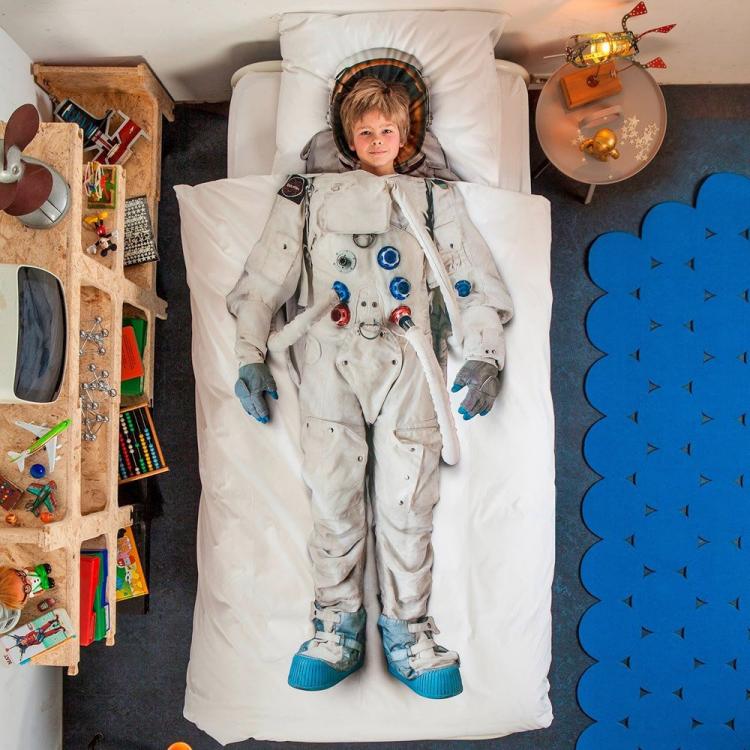 A white astronaut themed bed sheet on a grey floor