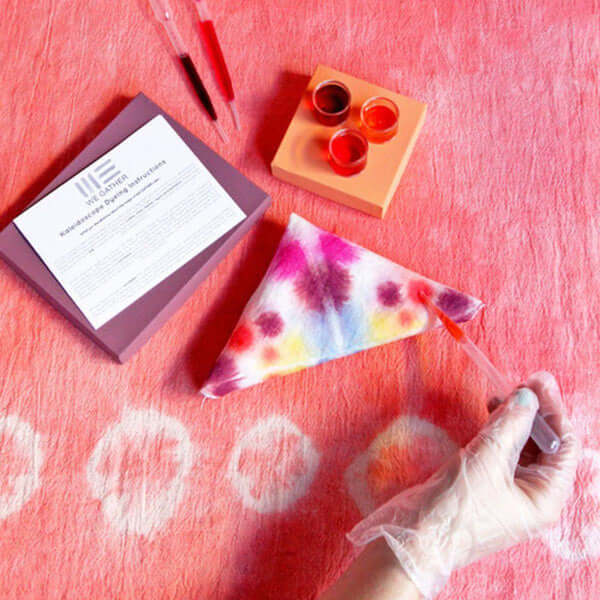 A DIY painted scarf with paints, pipettes and a purple box 