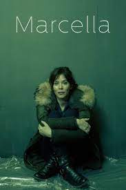 A dim light poster of Marcella movie in which a girl wearing a long coat sitting on a dirty floor 