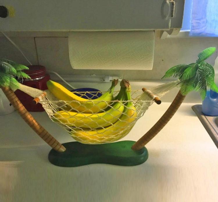 Coconut tree stand hammock with bananas on a white kitchen top