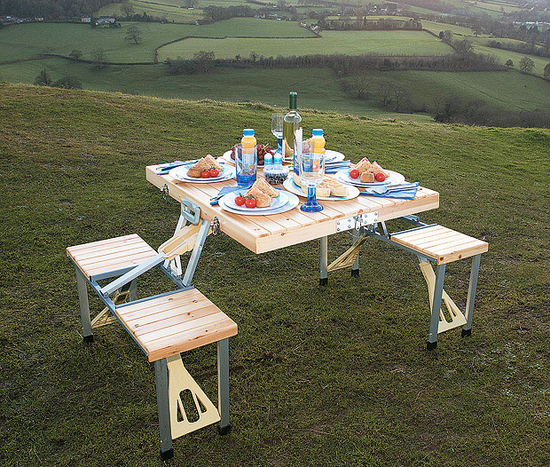 White-colored Wooden Picnic Table Folds Into a Briefcase full of foods and drinks in a grassland