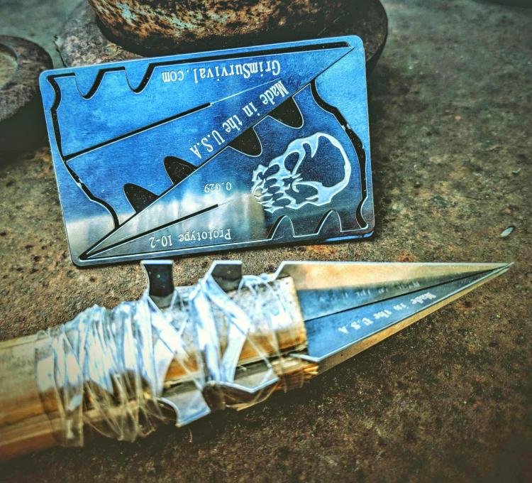 Stainless steel Credit Card Survival Spear with an assembled spear on the ground