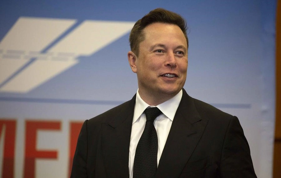 Elon Musk In A Black Suit While Smiling On Camera