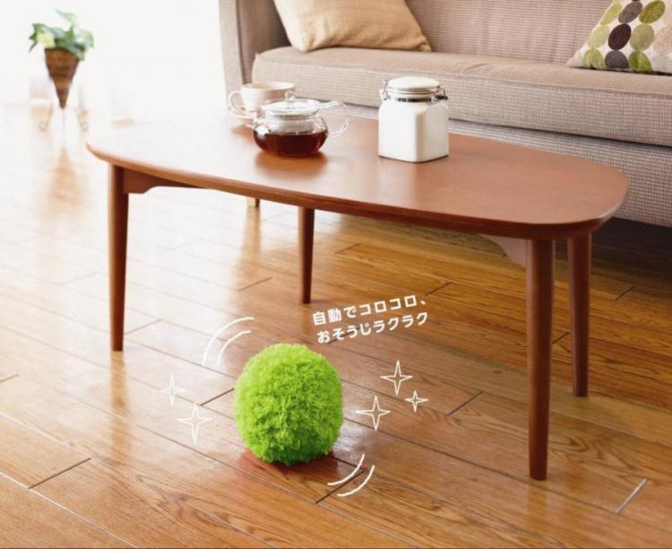 A green ball vacuum cleaner on the brown wooden floor