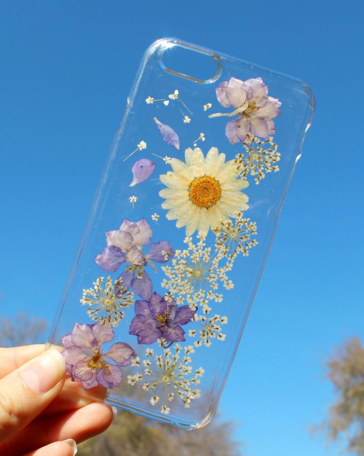 Purple flower, dandelion, and white daisy pressed into a transparent phone case