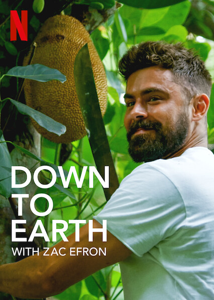 Zac effron wearing a white t-shirt cutting jackfruit from the tree with a large knife