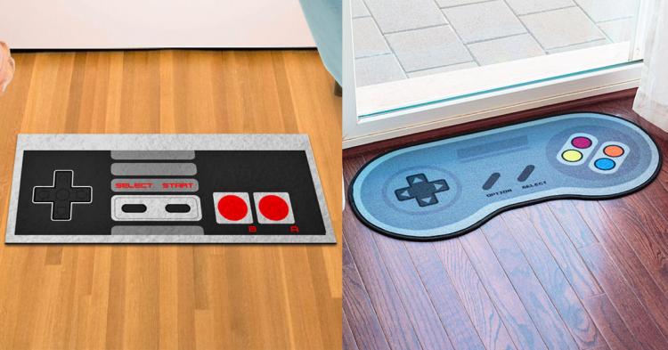 Black colored controller themed doormat with red polka dots and lack plus sigh on a wooden floor; grey colored controller shaped doormat in front of a door on a wooden floor with multi-colored dots 