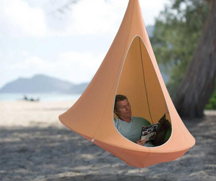 Skin-orange colored cacoon shaped hammock on the beach