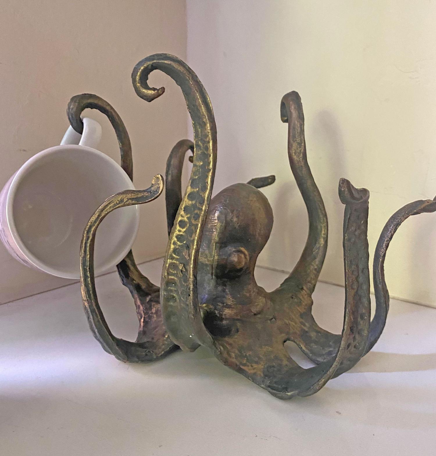 Rusty golden brown colored Octopus Coffee Mug Holder on a white kitchen top