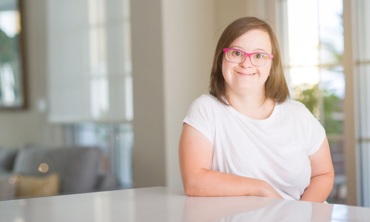 Down syndrome patient wearing a white shirt and pink glasses