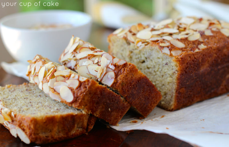Thick slices of almond banana bread is placed on a wooden plate