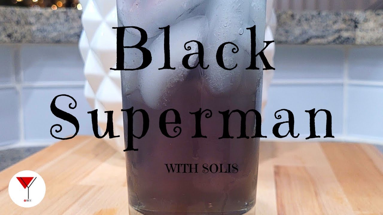 Black superman drink in a glass placed on a wooden table