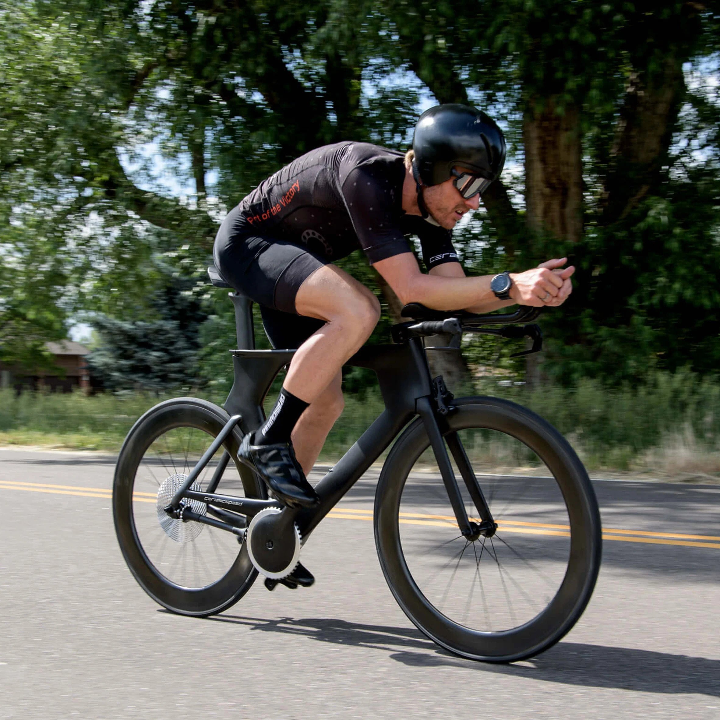 A man wearing black sportswear and riding a chainless bicycle