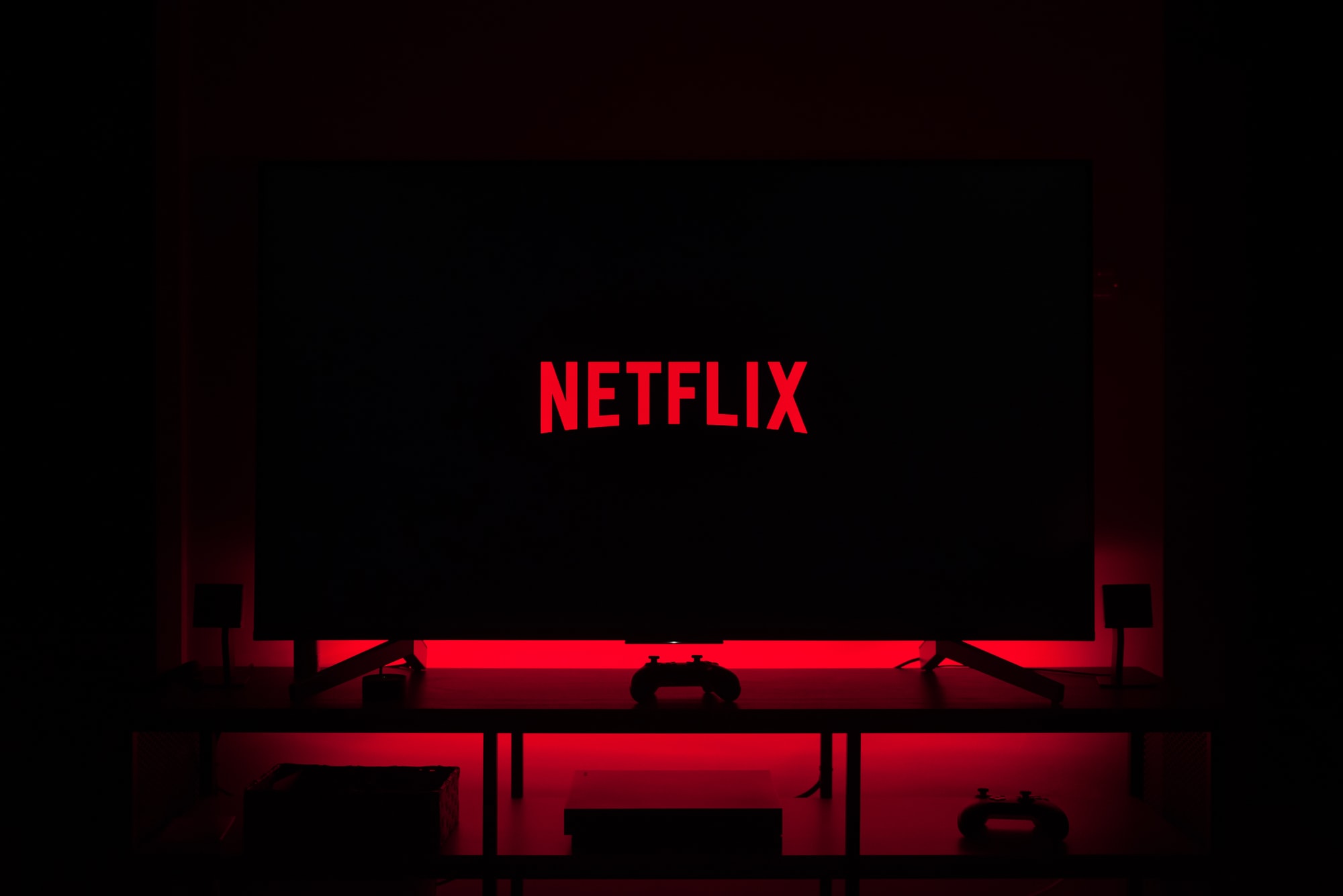 Netflix logo on LCD screen in a red glow-light room