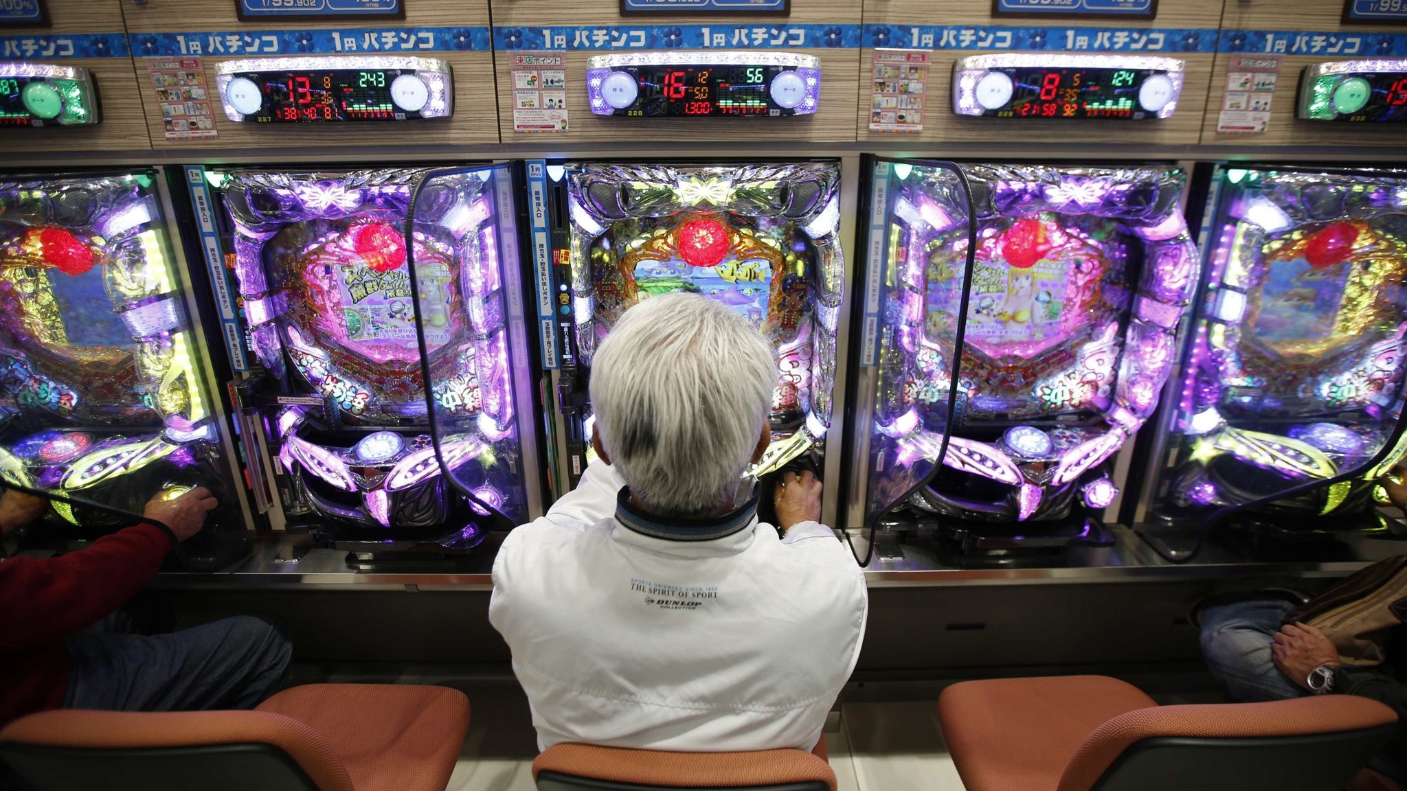 A man playing pachinko game on a pachinko machine