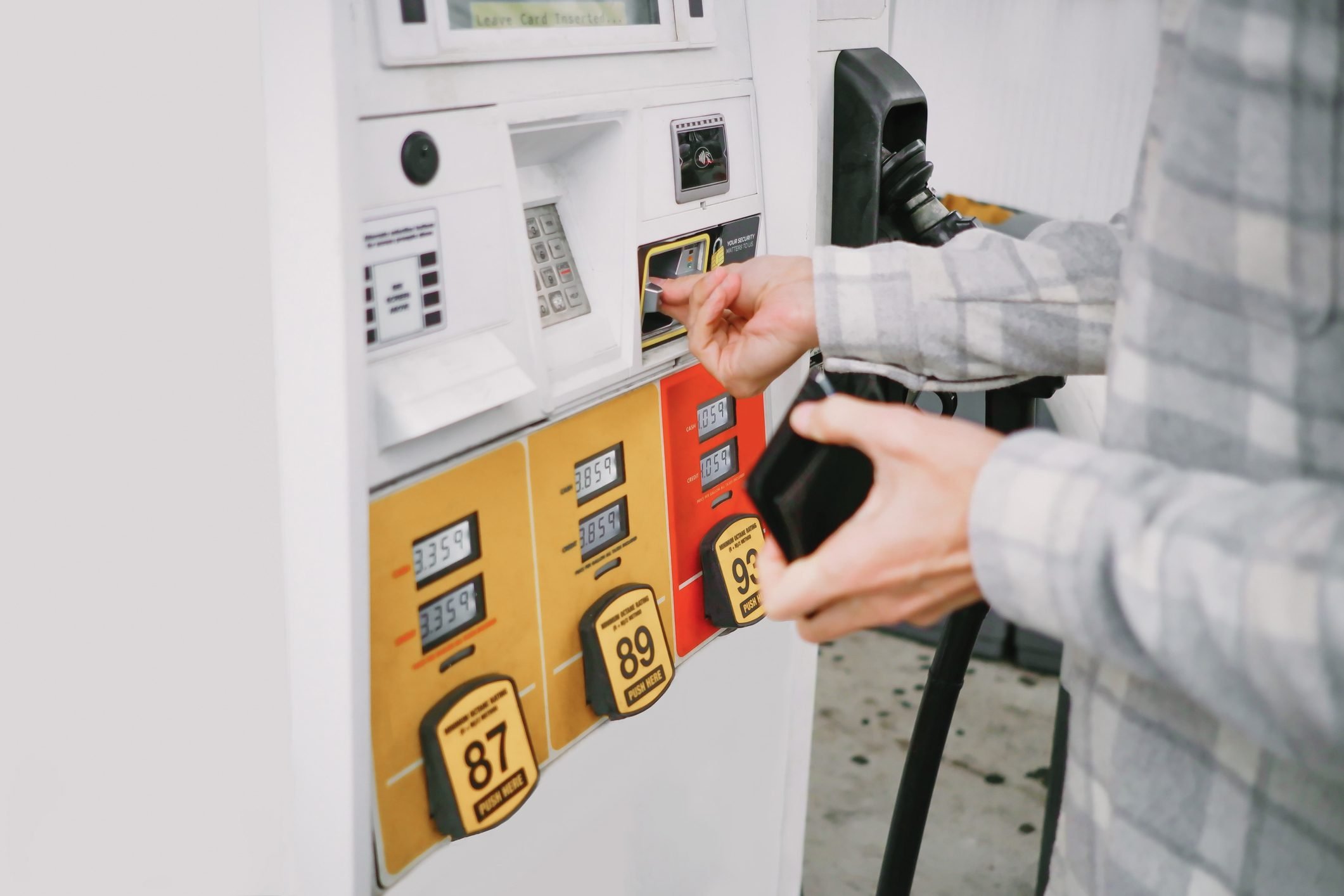 A man inserting his card in gas pump machine
