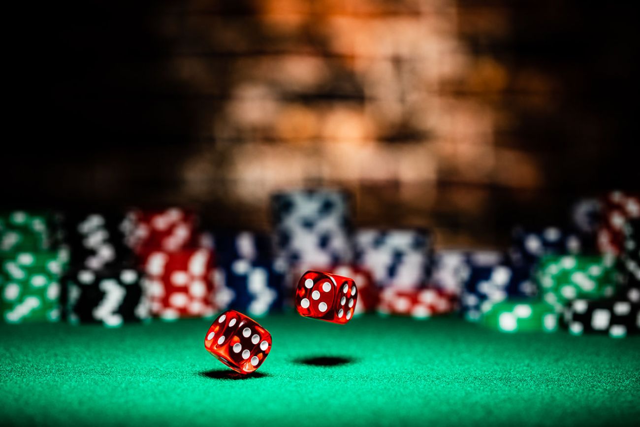 Two red dices with white dots on a green casino table