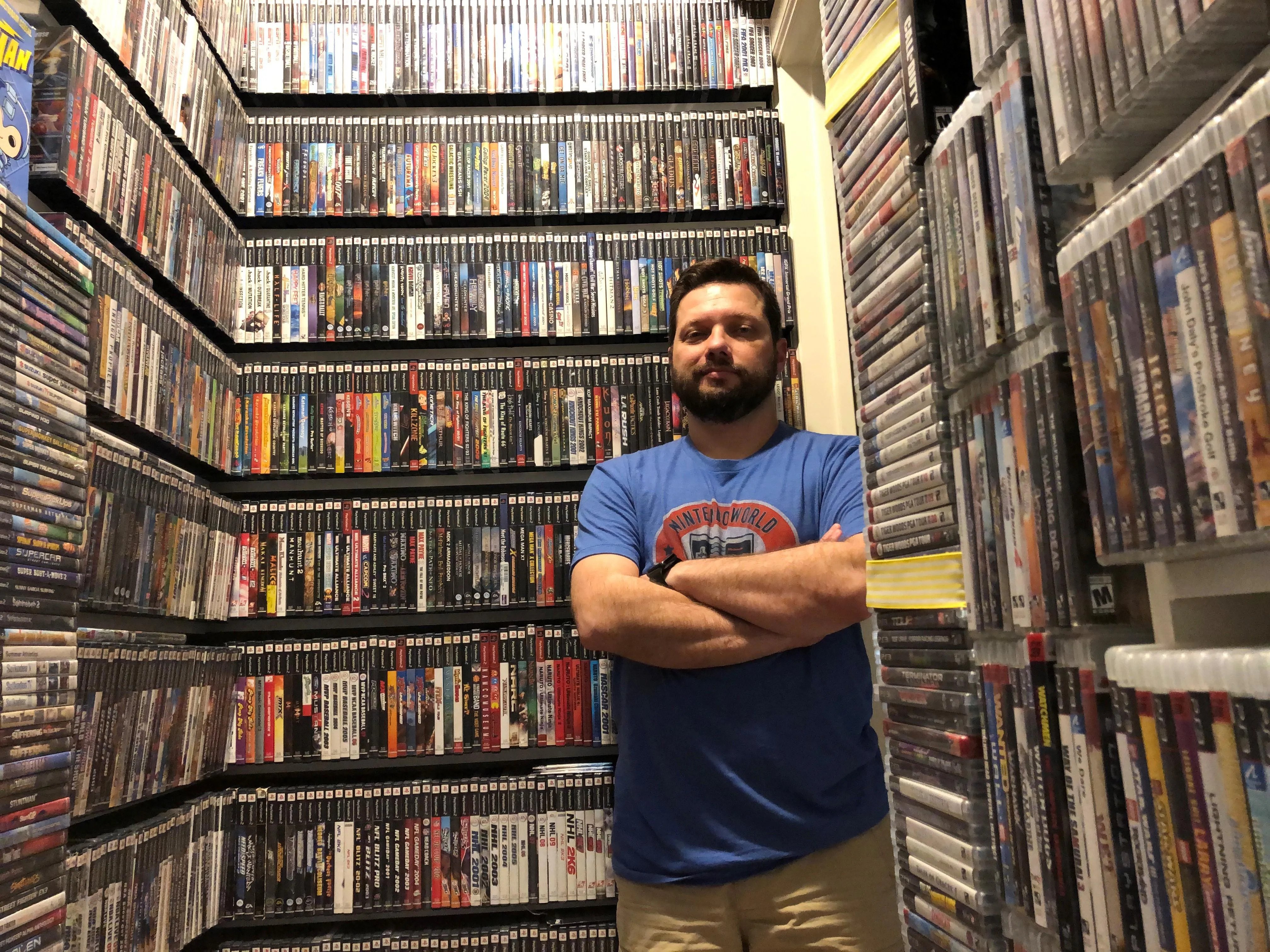 Antonio Monteiro standing in his video game library