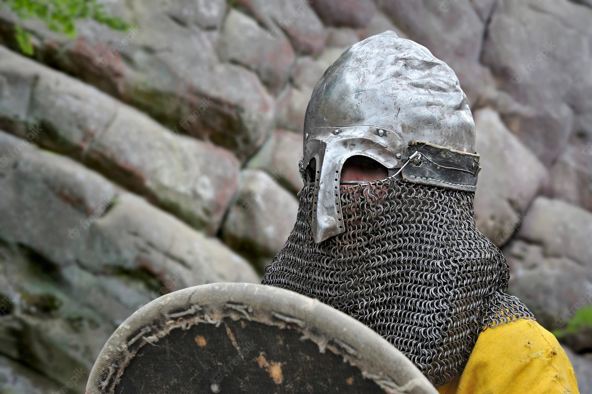 A man wearing a iron chainmail armor helmet